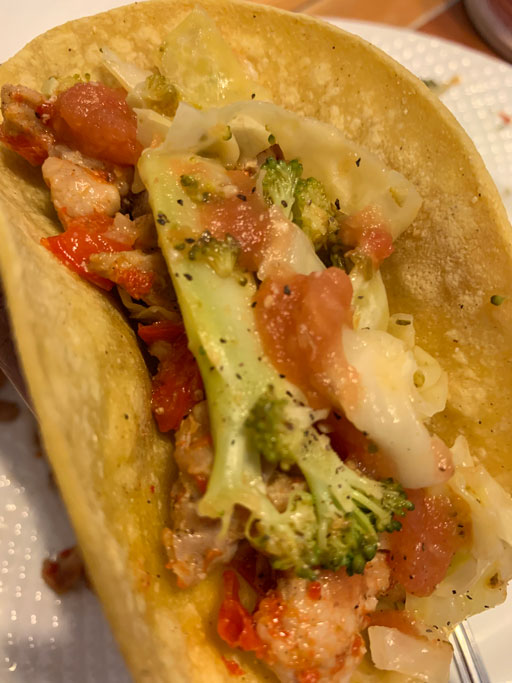 a taco with shrimp and vegetables